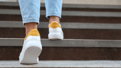 Close-up of feet walking up stairs