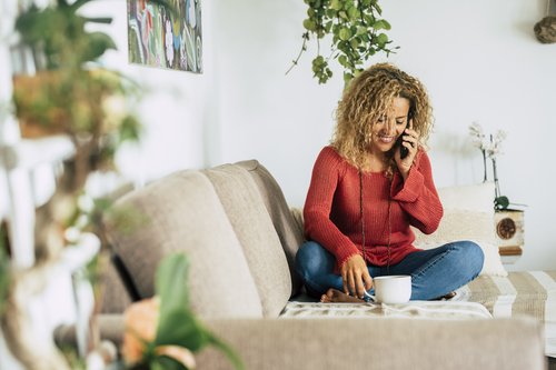 cheerful and happy woman at home talking on phone