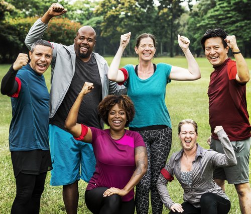 Group of cheerful diverse friends playing game in the park