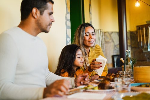 Parents and young daughter enjoying a meal together