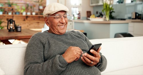 senior man texting at home