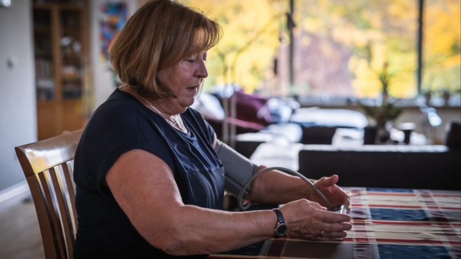 Woman taking blood pressure at home